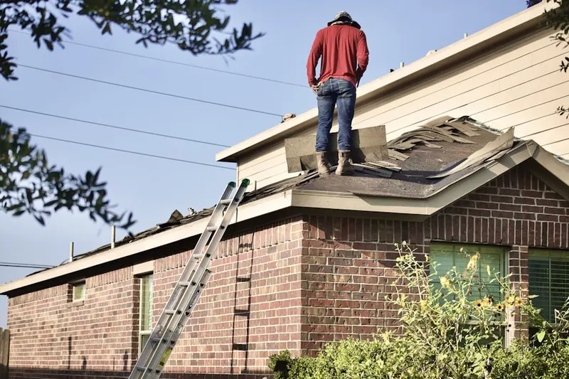Professional roofer working on a residential roof in River East
